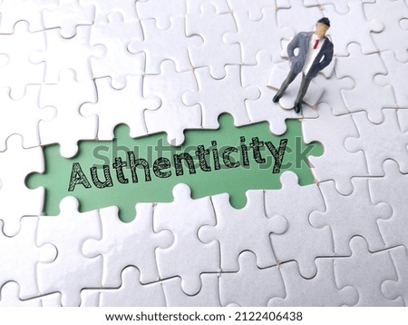 Top view miniature people with text Authenticity on a white puzzle background