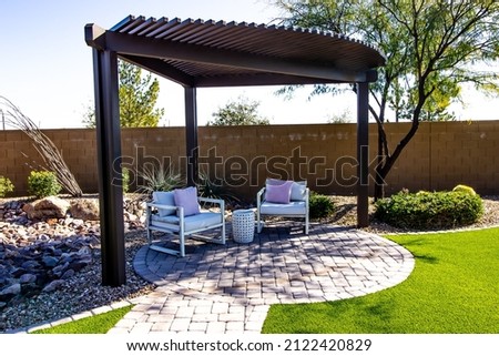 Small Back Yard Pergola With Two Sitting Chairs On Round Pavers Patio Royalty-Free Stock Photo #2122420829