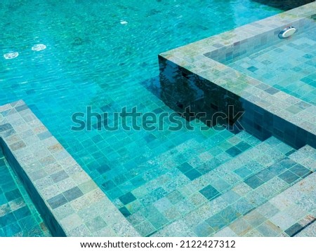 Swimming pool steps with clear water surface background, nobody. Abstract pool texture, underwater pattern blue background with grid tiles, no people. Overhead view. Summer background. Royalty-Free Stock Photo #2122427312
