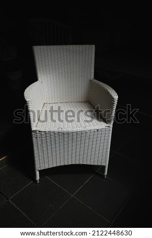 white patio chairs on a dark background