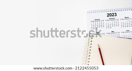 Calendar Year 2023 schedule with blank note for to do list on paper background. Flat lay with calendar. 12 months desk calendar 2023 with pen. Calendar desk 2023 on white background