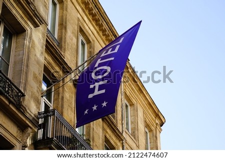 Hotel blue flag sign text three stars in wall building facade in french tourist city