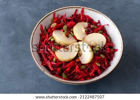 Salad of fermented apples with raw beets and carrots. Soaked or pickled apples are a traditional Russian dish. Royalty-Free Stock Photo #2122487507