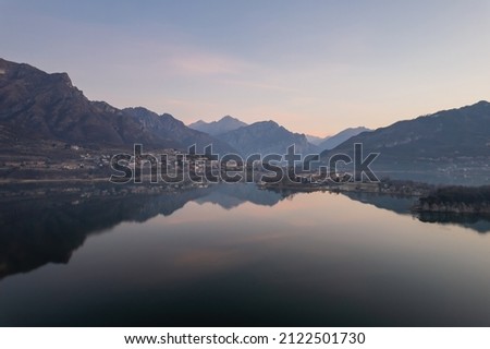 Civate town seen from Lake Annone before the sunrise. Reflection of the mountains on the water of the lake.