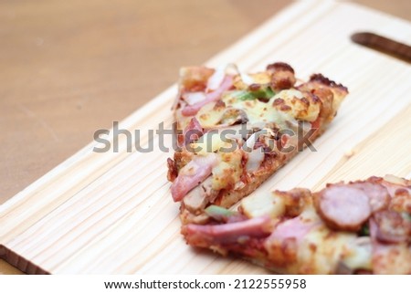 2 pizzas served on a wooden tray placed on a wooden table.