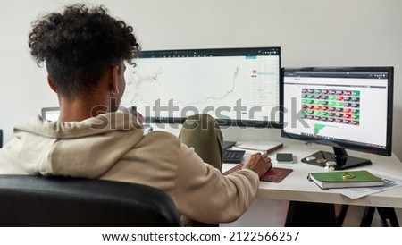 African american stock exchange trader watching data index chart stock market. Using multiple screens. Vaping electronic device. Cryptocurrency and finance, investor concept.