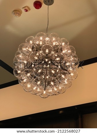 Big glass lamp chandelier hanging on ceiling wonderful modern Design interior decoration Technology electric abstract pastel background image buying now.