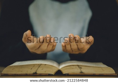 Christian life crisis prayer to god. Women Pray for god blessing to wishing have a better life. Hands praying to god with the bible. believe in goodness. Holding hands in prayer on a wooden table.