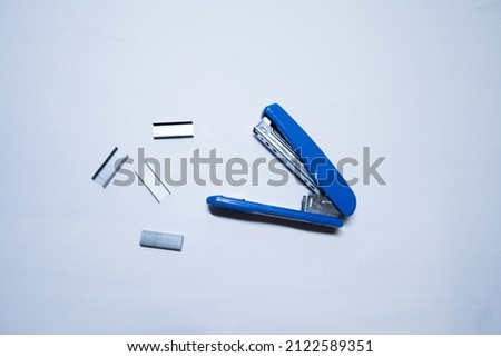 Stapler a machine for fastening together sheets of paper with white background