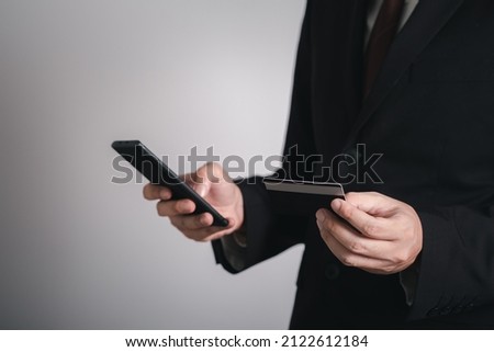 businessman is using a credit card with a smartphone for financial transactions. Online banking purchase product on internet in home office or online shopping. Convenience in the world of technology.