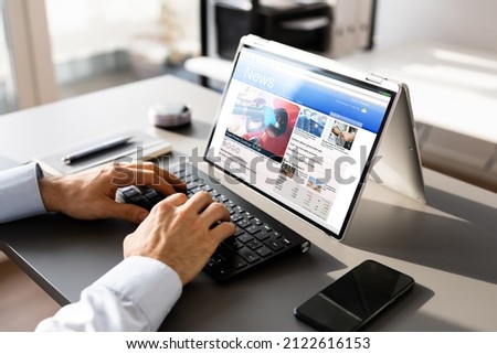 Watching News On Screen. Reading Newspaper Website On Laptop Royalty-Free Stock Photo #2122616153