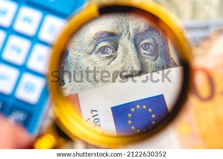 A person with a magnifying glass looking for money. Dollar and Euro together being observed in a photo with a blurred background. International business and world economy concepts.
 Royalty-Free Stock Photo #2122630352