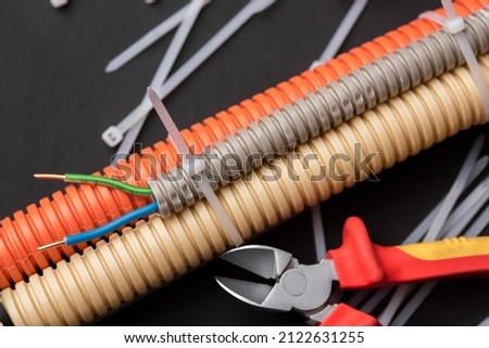 wire cutters with electric cable, plastic ties, and a colored outer shell for electrical wiring Royalty-Free Stock Photo #2122631255