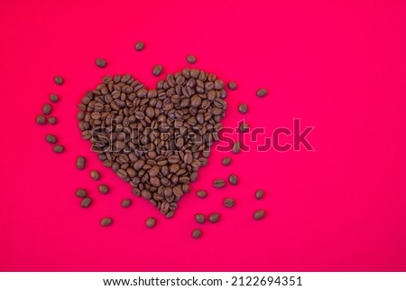 Heart shaped coffee beans on a crimson background
