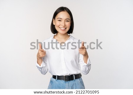 Its you congrats. Smiling attractive asian woman, businesswoman pointing fingers at camera with pleased face, complimenting, inviting you, standing over white background