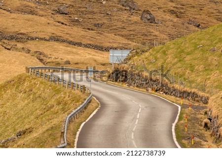 View of the road along the coast on the island of Vagar. Mountain landscape. Bour on Vagar Island. Faroe Islands.