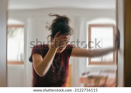 Blured photo of a woman suffering from vertigo or dizziness or other health problem of brain or inner ear. Royalty-Free Stock Photo #2122756115