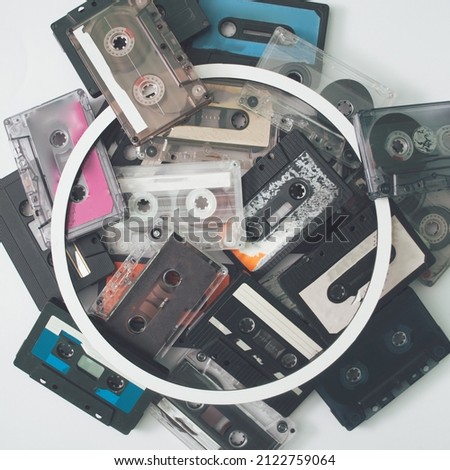 Set of old retro audio cassettes on white background with circle frame for copy space. Best of 90's hits. Flat lay, creative concept.