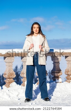 portrait of a young beautiful brunette woman in winter park