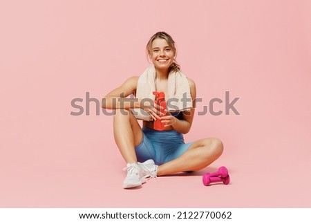 Full size young strong sporty athletic fitness trainer instructor woman wear blue tracksuit spend time in home gym drink water isolated on pastel plain light pink background. Workout sport concept. Royalty-Free Stock Photo #2122770062