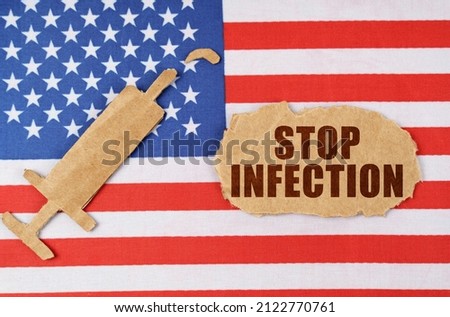 Medical concept. On the US flag there is a cardboard figure of a syringe and a torn cardboard with the inscription - STOP INFECTION