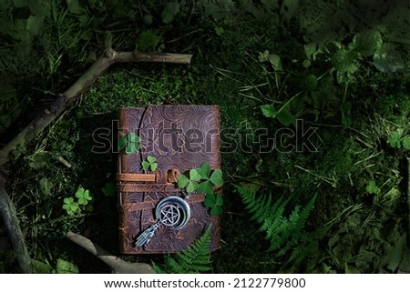 magic witch book and wiccan amulet with pentagram in forest, natural dark background. Esoteric Ritual, witchcraft, spiritual practice. Mysticism, modern wicca occultism concept. top view Royalty-Free Stock Photo #2122779800