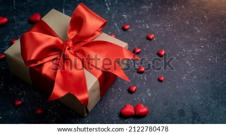 gift box with red ribbon on black stone