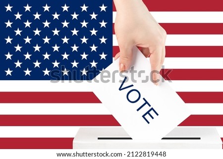 voting in the usa, a hand with a ballot against the background of the american flag puts the vote in the ballot box, congressional elections, the senate of political parties Royalty-Free Stock Photo #2122819448