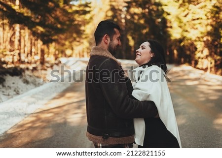 Beautiful couple moment, enjoying the cozy atmosphere of snowy winter days and hugging his girlfriend. Selective focus. High quality photo