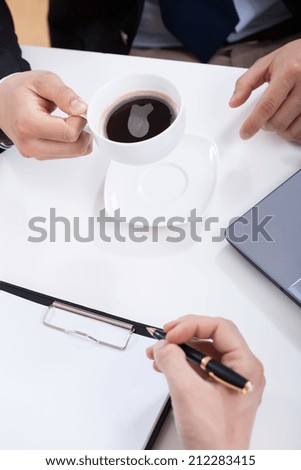 Close-up of a businessmen drinking coffee on a meeting