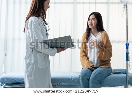 Asian woman patient visit and consult health problem with young doctor. Attractive beautiful female therapist practitioner working in office hospital to give advice treatment to sick girl sit on bed.