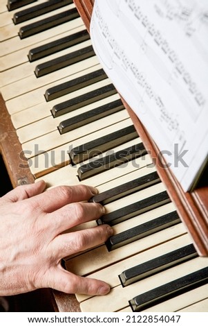 Closeup shot of the hand of a man playing the piano
