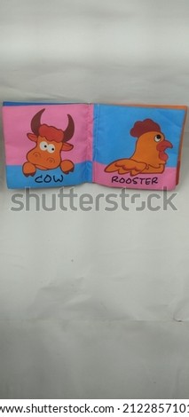 a children's toy with a picture of a cow and rooster looks colorful and beautiful