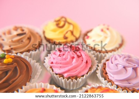 Cream cupcakes.cakes on a pink background.Cream dessert. Assorted sweet table. Sweets and desserts. Baked goods and desserts