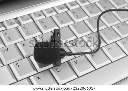 Lavalier microphone on computer keyboard, broadcasting, blogging and streaming online concept