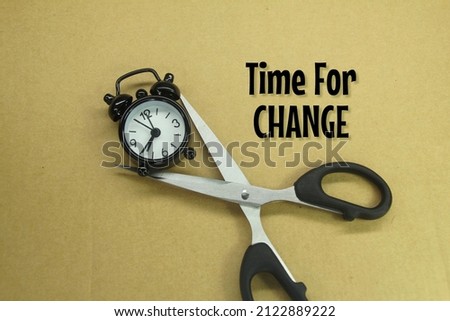 scissors and an alarm clock with the words time for change