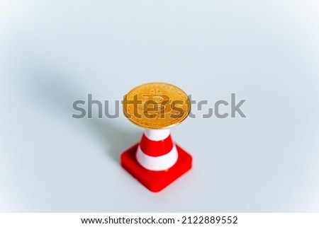 An abstract shot of a bitcoin coin on a white background and a road sign.growing cryptocurrency market, Electronic money that has no equivalent in paper money. High quality photo