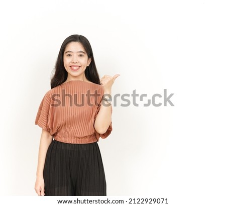 Showing and Pointing Product With Thumb Of Beautiful Asian Woman Isolated On White Background