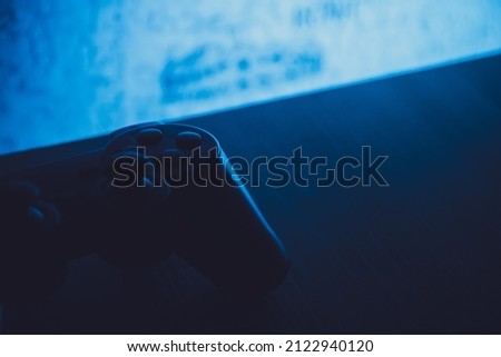 gamepad lies on the table in the dark with blue backlight