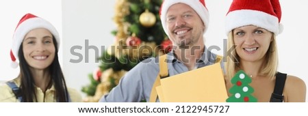 Group of postmen in red santa hats holding letters and boxes with gifts. Postal services in new year concept