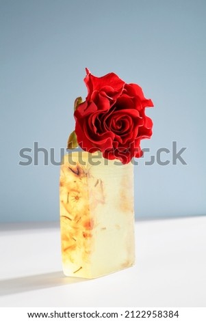 beautiful handmade natural soap with red rose on white and blue background. organic simple, eco friendly, spa skincare concept. 