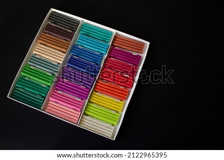 rectangular pieces of multicolored plasticine, in a white box on a black background