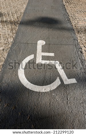 Handicap Sign on Paving - Barcelona Spain / White markings representing a wheelchair, in a route reserved for handicapped in Barcelona, Spain