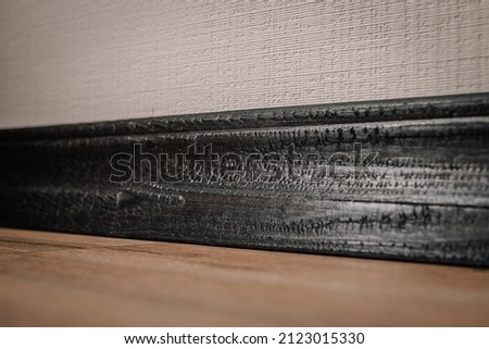 burnt and varnished board surface in brown and black