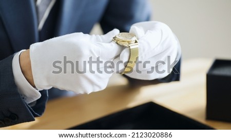 An appraiser assessing a watch Royalty-Free Stock Photo #2123020886