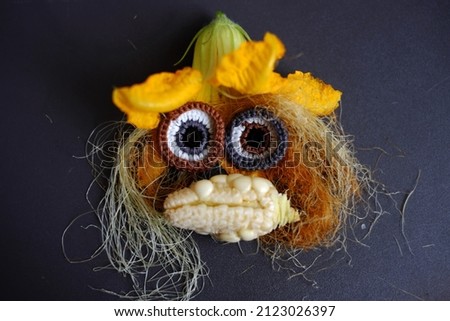 Funny face set up from food, agriculture product from rooftop garden, small corn, pumpkin flower, corn silk and eyes crochet from yarn make cute
