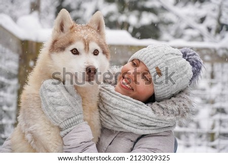 Image of young girl with her dog, alaskan malamute, outdoor at autumn or winter. domestic pet. Husky.