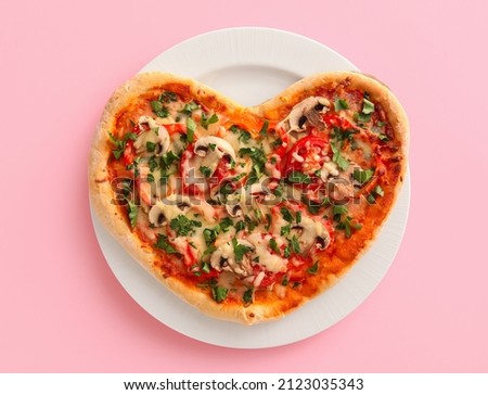 Plate with tasty heart-shaped pizza on pink background. Valentine's Day celebration