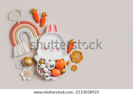 Easter  decoration with cute plate in the shape of a bunny with  Easter eggs, candy, carrot and flowers. Happy Easter concept. Idea for Easter dinner