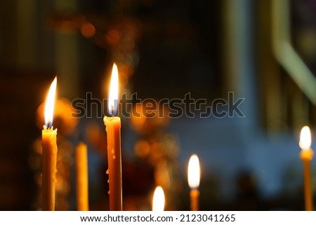 Candles in a Christian Orthodox church background. Flame of candles in the dark sacred interior of the temple Royalty-Free Stock Photo #2123041265
